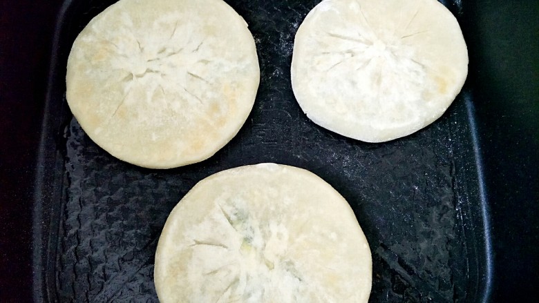 韭菜馅饼(超详细版),表面有鼓起的部分就可以翻面了,颜色不够就再翻过去烙,翻的时候要小心,不要把侧面弄破。有电饼铛是最方便的了