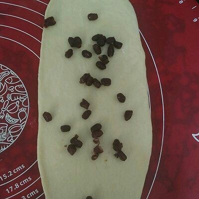 蜜豆椰蓉吐司,取一个面剂擀面皮长条状,撒蜜豆