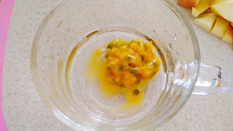 百香果苹果汁(排毒养颜),用勺子把一半的百香果肉汁放杯子里