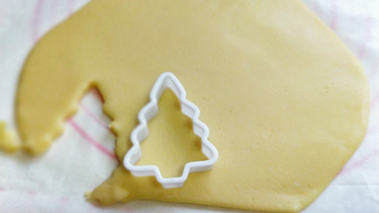 圣诞树饼干#预热圣诞节#,用模具压出圣诞树🎄,小心去掉周边的面片,去掉的面片还可以重复步骤再次擀圆饼再压出圣诞树🎄。