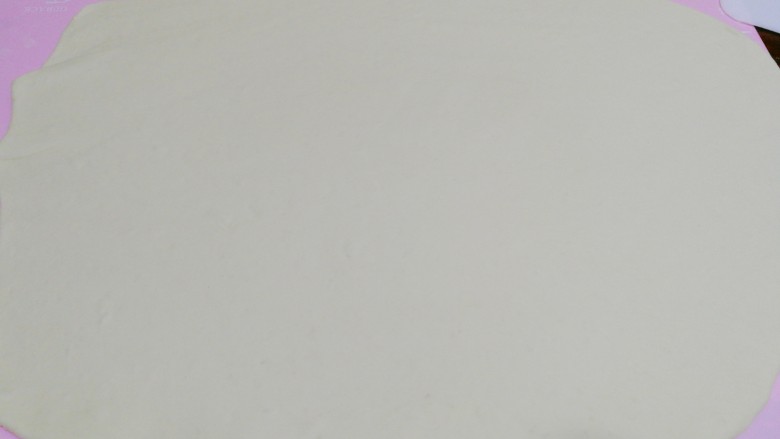 最爱包子+切着吃的肉卷包子,先取其中一块,将面团揉成方形,用擀面杖擀成大饼状。