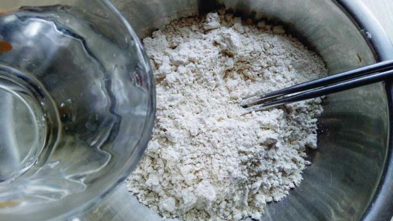 凉拌莜面鱼鱼,分次加入开水。(切记不要一下子将开水倒入,不同的面粉吸水性不同,一定要分次加入开水)