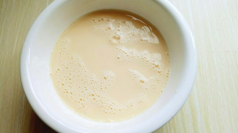 水果千层蛋糕,加入牛奶,用手动打蛋器抽打均匀。(使牛奶和鸡蛋完全融合)
