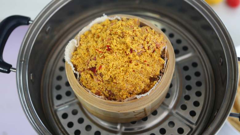 小米蒸排骨,汤锅中倒入水,大火烧开,放入蒸茏小米排骨,转小火蒸1小时