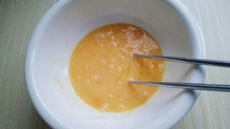 快手早餐~芝香馒头丁,用筷子将鸡蛋打散。