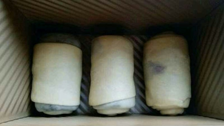 最爱面包+豆沙馅小面包,放入模具中,放入烤箱进行二次发酵。
如果有小面包的模具用小面包的模具最好啦!我没有,只能用吐司盒啦!发酵至是原来的2倍大即可进行烘烤。 约35分钟左右,二次发酵完成。(发酵特别好呦) 烤箱180预热 将烤网放入烤箱底层,把模具放在烤网上,盖上模具盖子,180度烤30-35分钟。