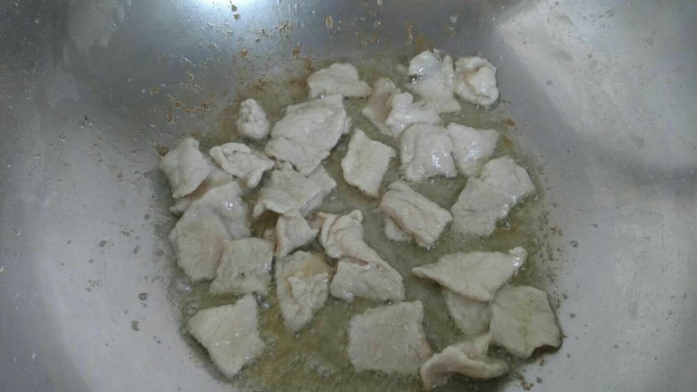 青椒胡萝卜炒肉片,油大约七分热时放入肉片,煸炒至变色。