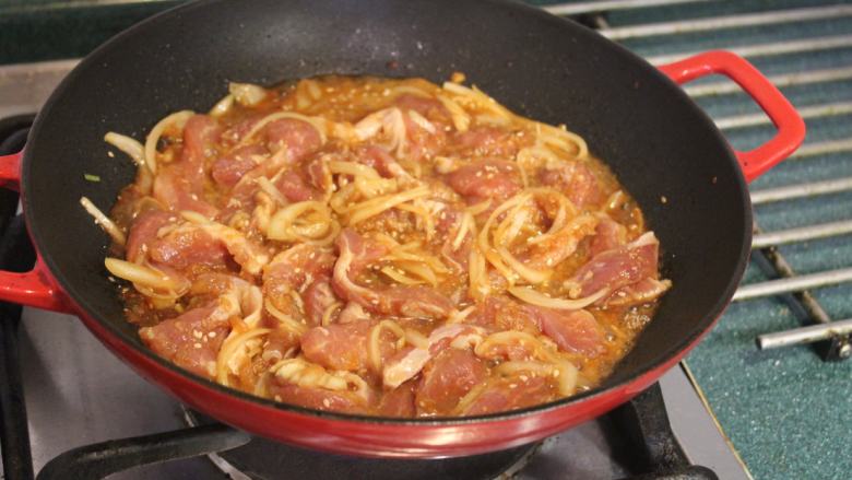韩式烧肉,铁锅大火烧热后放少许油润锅,将烧肉连同酱汁一起入锅。