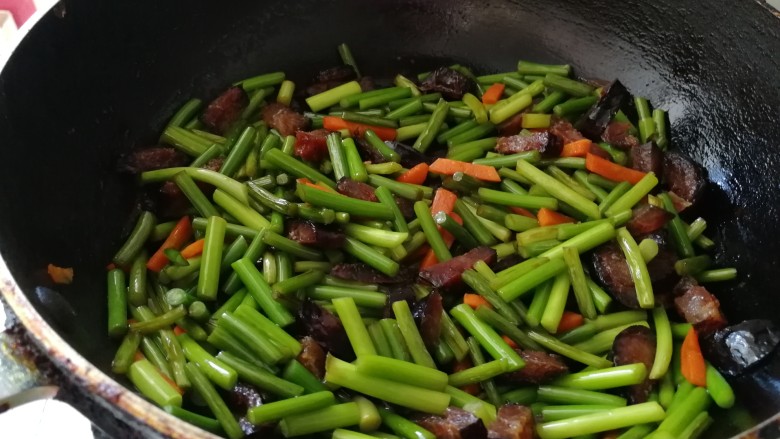 腊肠炒土豆条蒜苔,加腊肠翻炒,加半小碗水,也可以加淀粉水。
