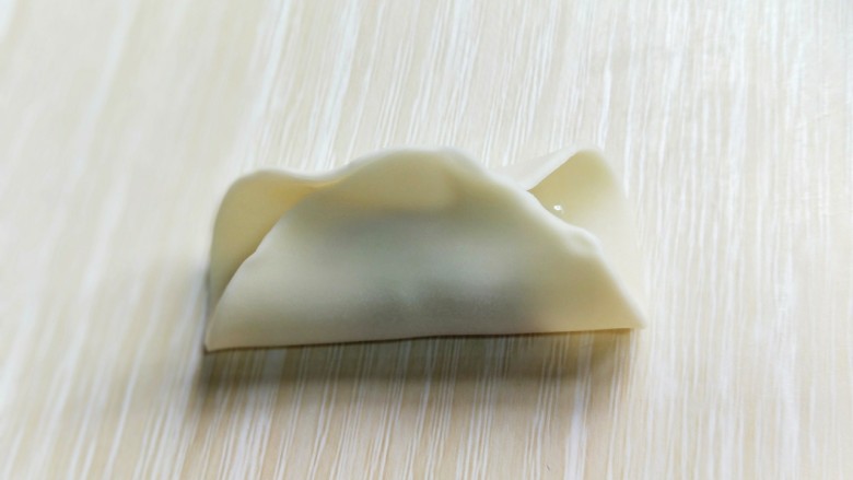 芹菜猪肉水饺,将饺子皮对折,如图。