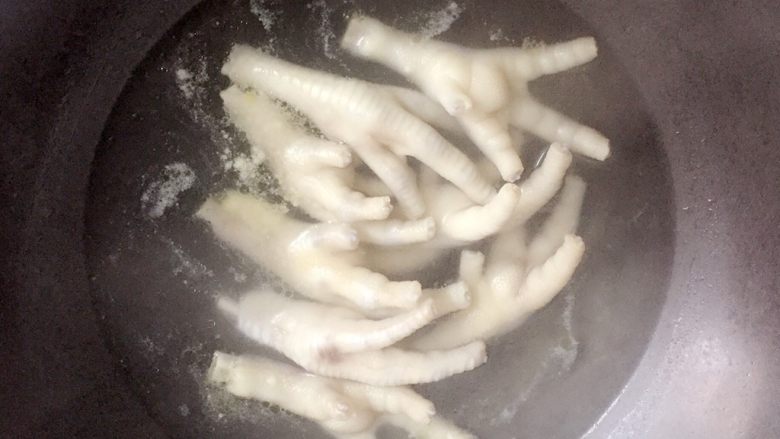 卤鸡爪,锅中放水烧开后,把鸡爪放入沸水锅中焯去血水。