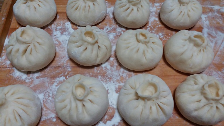#面包还是包子#+猪肉酸菜包子,包好的包子放入笼屉里醒15分钟就可以开大火蒸20分钟,关火后闷3~5分钟就可以开锅盖取出了。