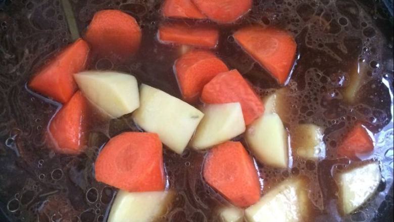 家常的美食胡萝卜土豆炖牛肉,加入切好的胡萝卜，土豆块。