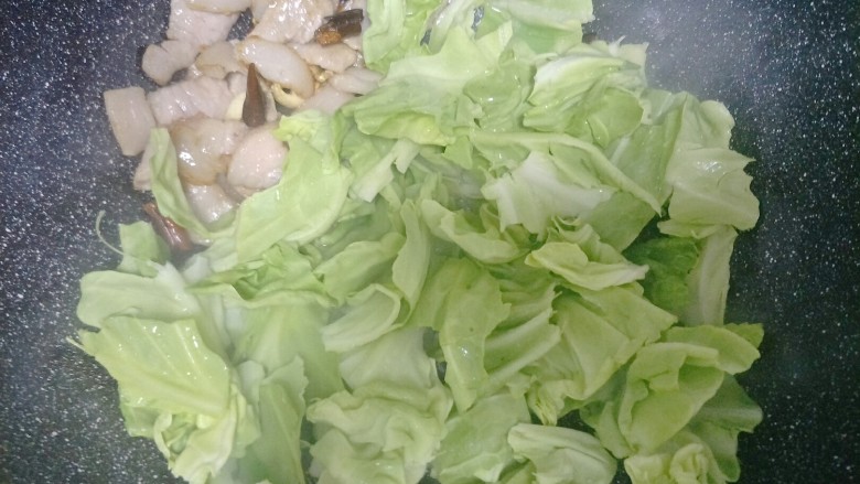 手撕包菜,把包菜倒入锅中,用铲子按一按包菜