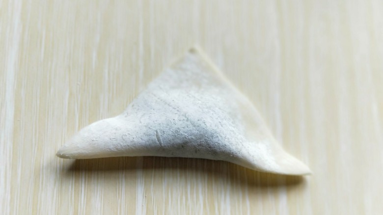 一碗面条+#营养早餐#馄饨面,将馄饨皮对折,折出三角形。如图