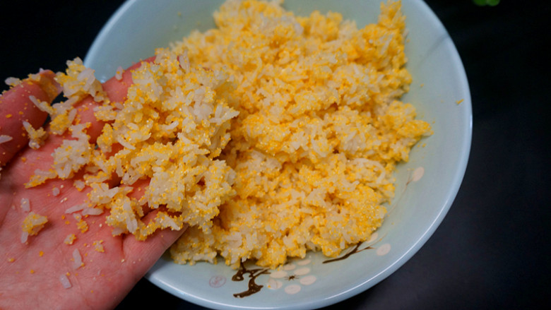 黄金玉米饭,用手搅匀,让米饭和玉米粉彻底综合在一起,在这个过程当中要用手感受一下干不干,太干蒸起来不好吃