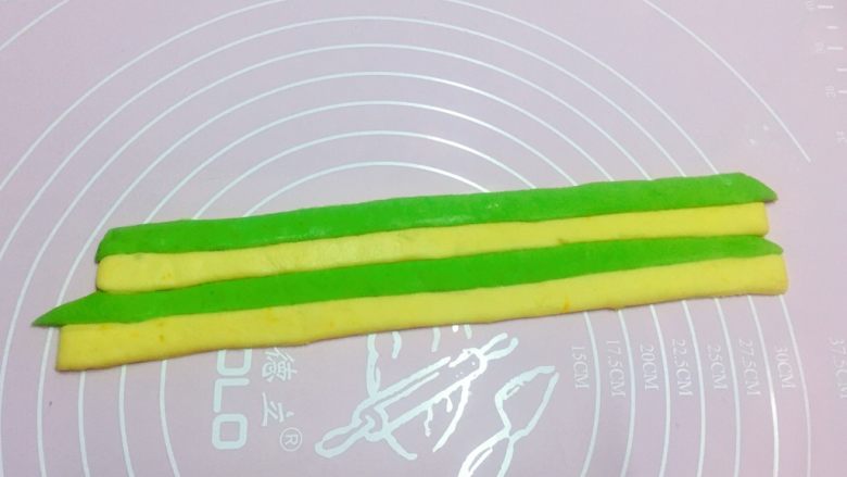 最爱包子+足球包子,然后将切好的黄色和绿色长条并排放在一起,侧面粘紧,两手在两边往中间轻推,使黄绿色紧紧的粘在一起,再继续粘下一条。(如果侧面干不好粘,就刷薄薄一层水)