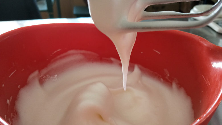 可可软嫩蛋糕,继续3档打发。蛋白变得更加细腻,开始有细微的纹路,拉起打蛋头,蛋白糊会垂下一个长长尖,不会滴下来,加入剩下的糖(第三次加糖)。