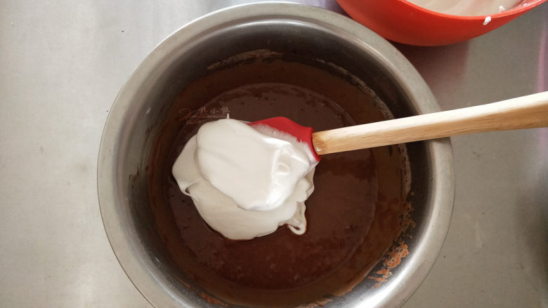可可软嫩蛋糕,将1/3的蛋白霜加入到可可蛋黄糊中,搅拌均匀。这个时候要拌匀,多翻拌一会没关系,使蛋黄糊和蛋白霜的密度接近,下一步才好拌匀而不易消泡。