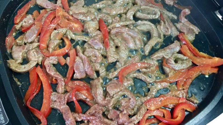 嫩牛肉卷饼#感恩节食谱#,红椒爆香之后,再倒入腌好的牛肉翻炒。