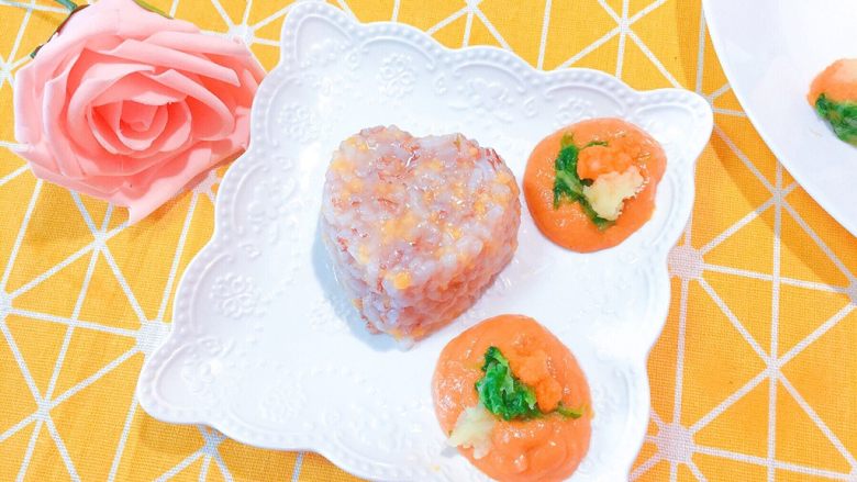 婴儿造型辅食之@@心爱的彩球,然后再拿一个碟子。把用心形模具压制好的稀饭扣在盘子里。然后摆上亨氏番茄鳕鱼泥,在上面各加一点电的土豆泥+蔬菜泥+胡萝卜泥点缀。