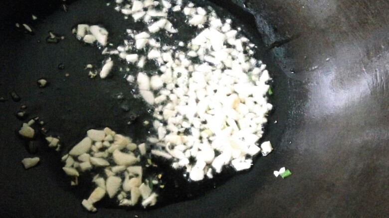 营养美味捞面,炒瓢里下少许油,再加入蒜粒炸香。