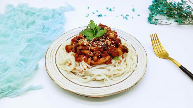 一碗面条+花生酱蟹味菇肉丁面,将面条夹在盘子里,将酱料放上面即可。