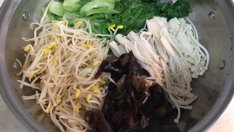 煮鱼片,煮配菜:
冷水烧开,加适量盐,依次放入木耳、金针菇、生菜、豆芽煮熟捞出铺在盆底(一楼)。