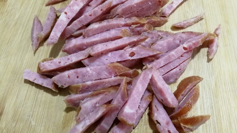 红肠油麦下饭菜,红肠先切片,再切成条。
