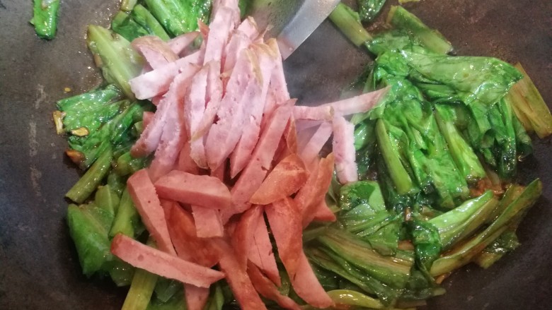红肠油麦下饭菜,接着倒入红肠,快速翻炒几下。