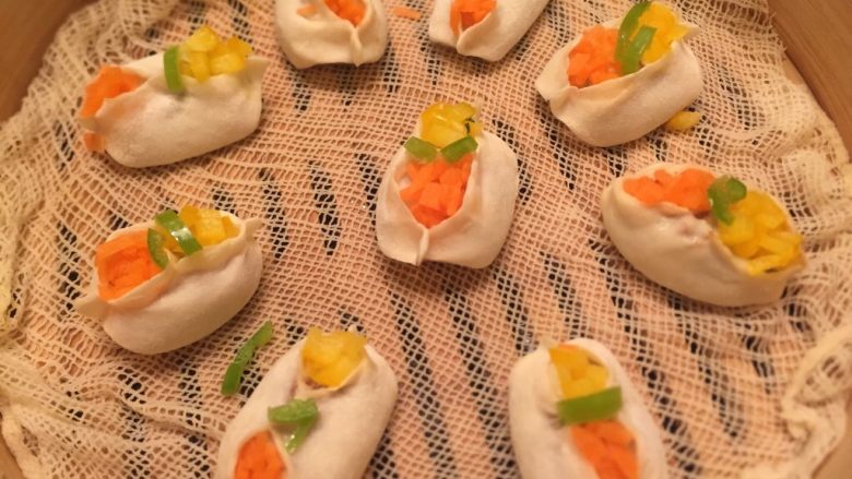 花样蒸饺,饺子放入蒸屉,放入胡萝卜,彩椒丁。