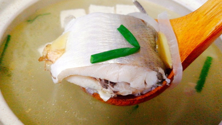 #感恩节食谱#+午鱼萝卜丝豆腐汤,鱼煲好了,加入香葱,鸡粉调味,看看这个肉质 诱人吧,装到砂锅里即可