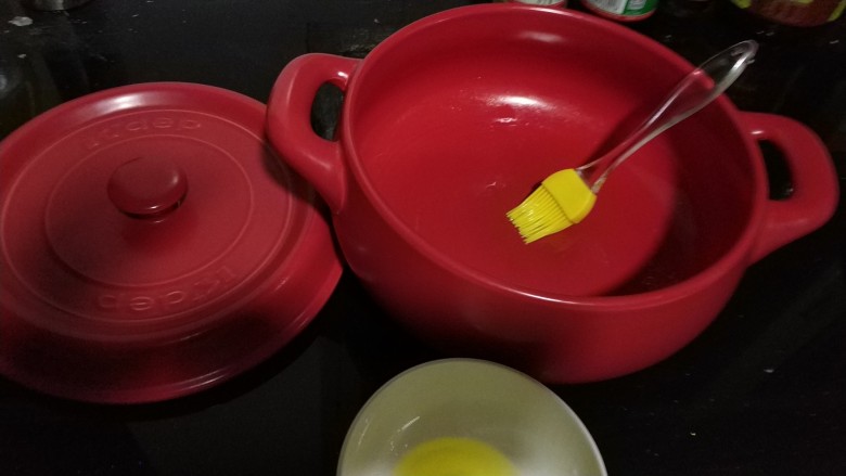 广式腊肠煲仔饭,在锅底刷上一层花生油,要多放一些油,不然容易糊底,把泡过水的米带水一起放到锅里煮。