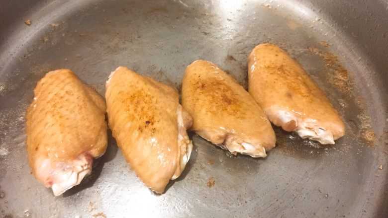 营养爱心便当🍱,鸡翅放进锅里煎,一边煎到金黄再翻煎另一面,等到可以用筷子穿过肉里就可以了