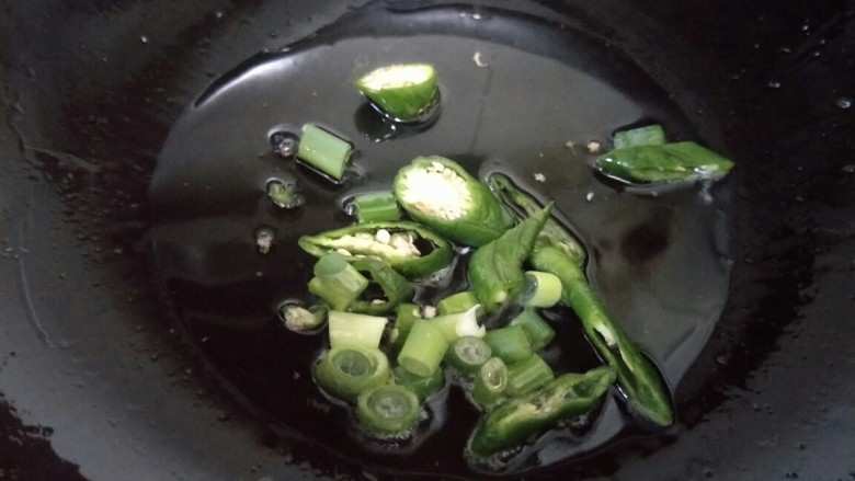杂蔬炒鸡蛋,锅中加油,烧热,放入葱花和青椒炒香。