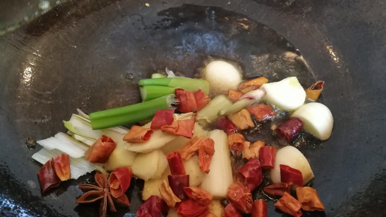 家常美味炖青鱼,放入八角,红辣椒段,快速的炒一炒,