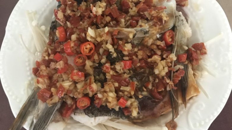 剁椒鱼头,把炒好的剁椒倒入盘里，平铺在鱼头上