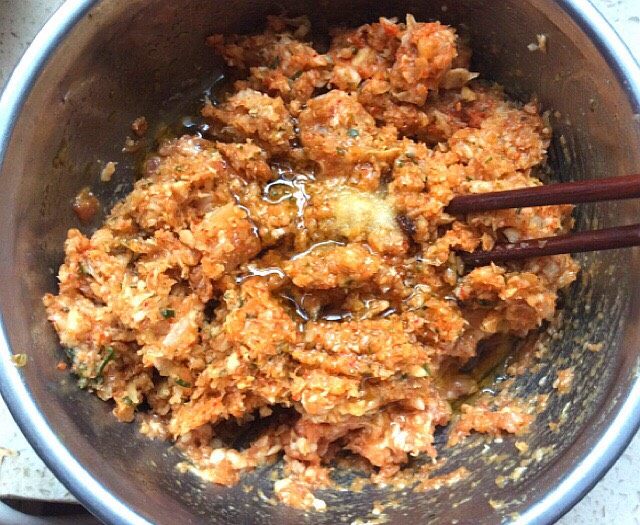 辣白菜大肉饺子,把菜放入肉中加入适量的熟油,盐,拌匀