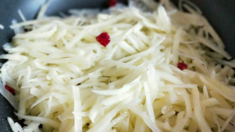 圆土豆+酸辣土豆丝卷饼,热油锅,加入切好的<a style='color:red;display:inline-block;' href='/shicai/ 86663'>红辣椒</a>和蒜炒香,加入土豆丝。
