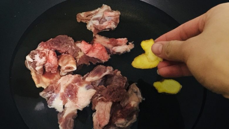圆土豆+萝卜牛腩煲,锅中放水,放入牛腩,生姜,料酒去腥味。
