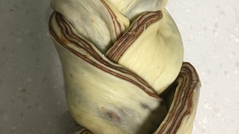 大理石纹豆沙吐司,编成辫子,切口朝上翻出。编辫子要最大限度的松,才不影二发。