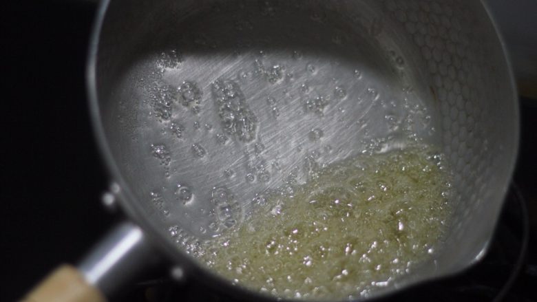 老北京小吃之冰糖葫芦,注意!随着时间的推移,糖水里水份蒸发,均匀受热状态下糖浆会先变成这种浅黄色,这个时候要打起精神,一定看好了不要过火,变成深褐色就是糊了,得扔。只要通晓熬糖的原理,我们常见的拔丝山药之类的菜也可以搞定。像这个状态再熬个半分钟糖泡变成芝麻大小就可以做拔丝。