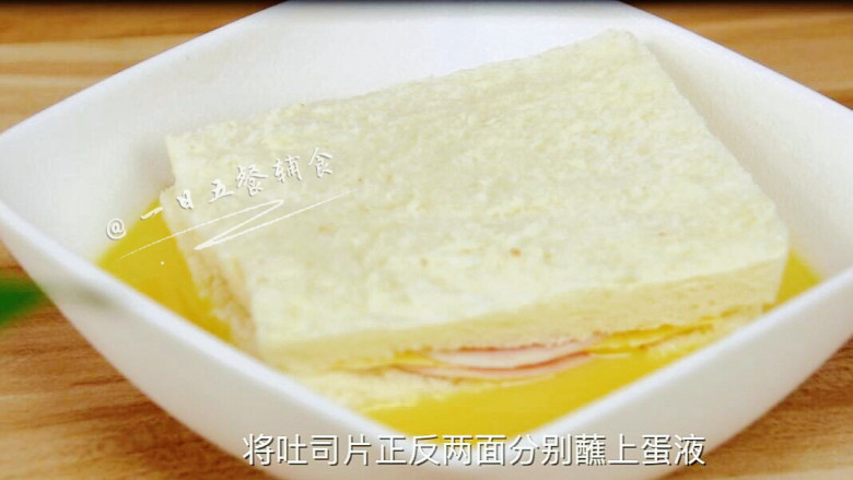 火腿芝士西多士,将吐司放进蛋液里,双面蘸上蛋液。这里只要双面蘸上就好,不要泡太久。
