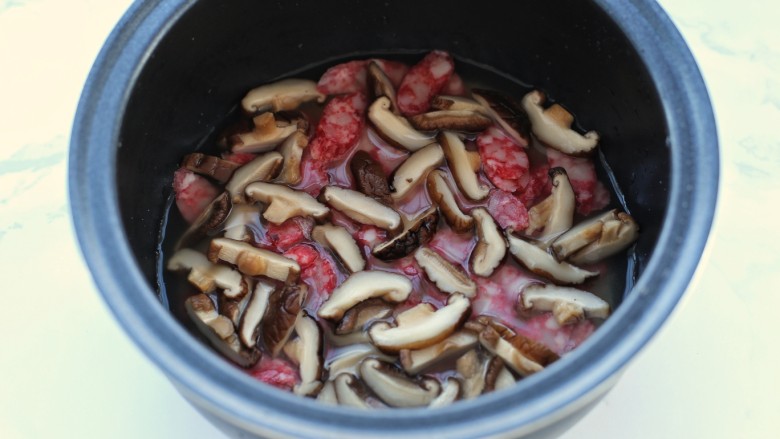 电饭煲腊肠煲仔饭,将<a style='color:red;display:inline-block;' href='/shicai/ 492'>大米</a>淘洗干净后加入泡香菇的水,再加清水到正常煮饭的水量,将腊肠和香菇铺到上面,按煮饭键开始煮饭