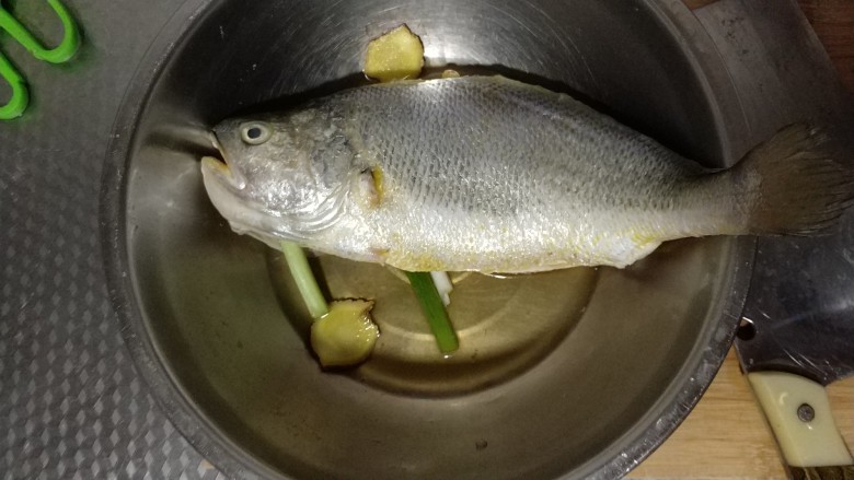 砂锅鱼炖豆腐,把清理好的鱼放入容器中,在鱼腹中塞一些葱花和葱段,倒入<a style='color:red;display:inline-block;' href='/shicai/ 718'>料酒</a>,腌制15分钟左右。