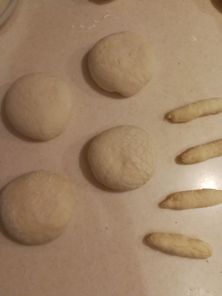 蘑菇豆沙包,包好后压扁,剩余面团搓条用来做蘑菇的尾巴。