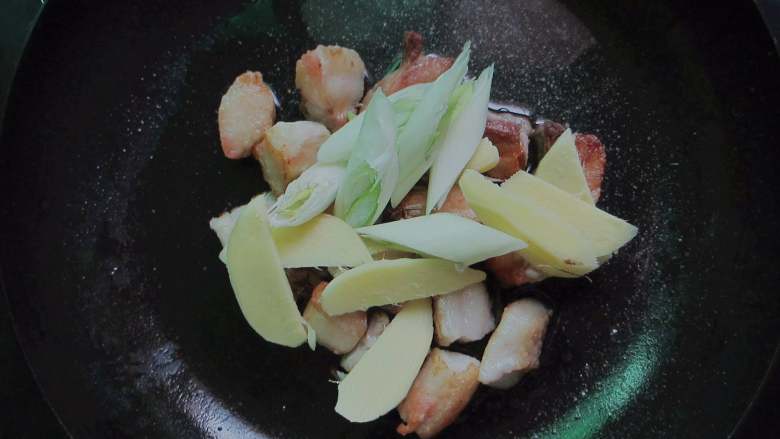 千张结烧肉,加入葱段,姜片煸炒出香味