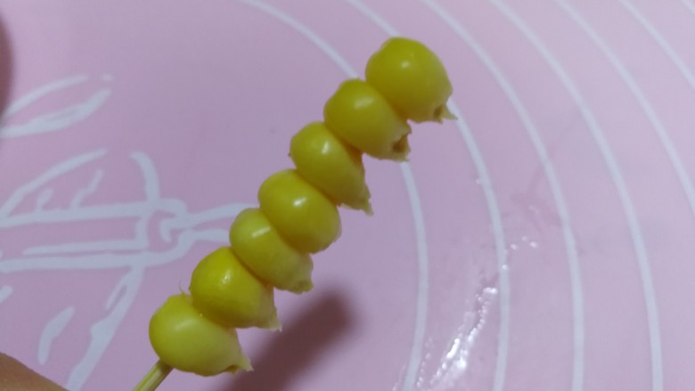 甜蜜的黄金米粒,下面我们将泡好的玉米粒儿,用牙签儿穿起来,一个牙签儿上穿七个玉米粒儿。