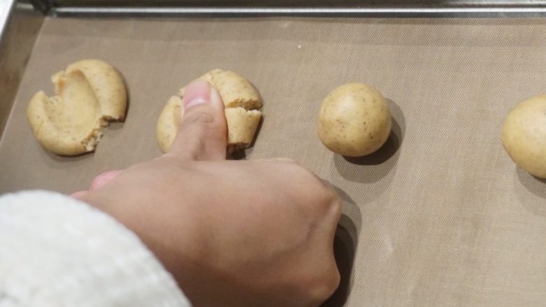 咖啡樱桃玛格丽特高纤饼干,用拇指指腹将小圆球面团逐个压扁;