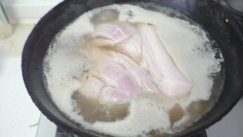 老潼关肉夹馍,猪肉切块入锅,倒入没过肉的清水,水开焯去浮沫后再煮3分钟左右,把肉捞出,水倒掉不要。